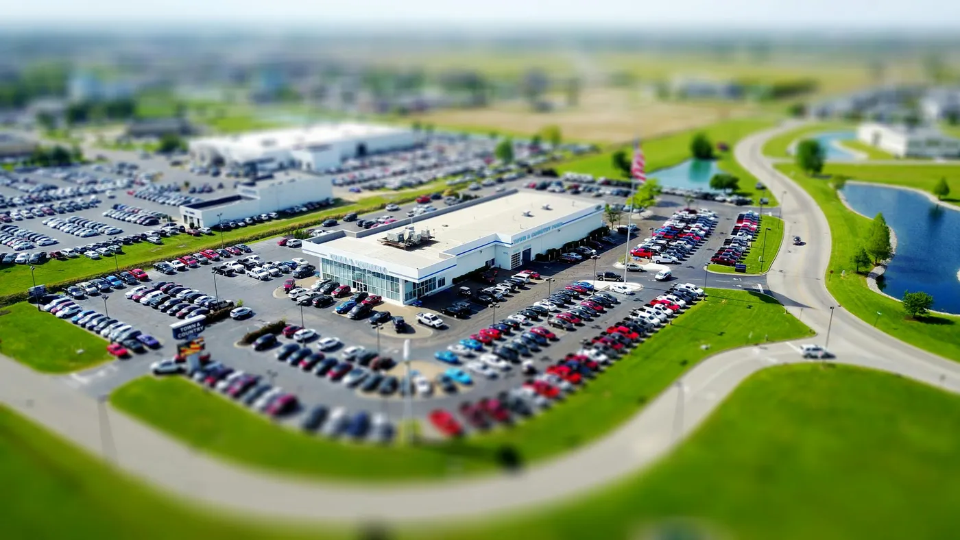 A dealership and its full parking lot seen from the air