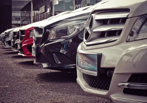 A row of cars parked nose to tail on the forecourt